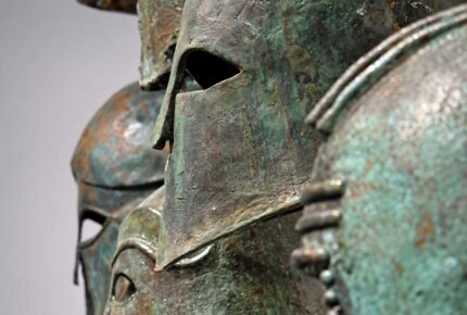 Ancient Greek helmets and historical artworks in the Ancient Symposium art gallery in Athens